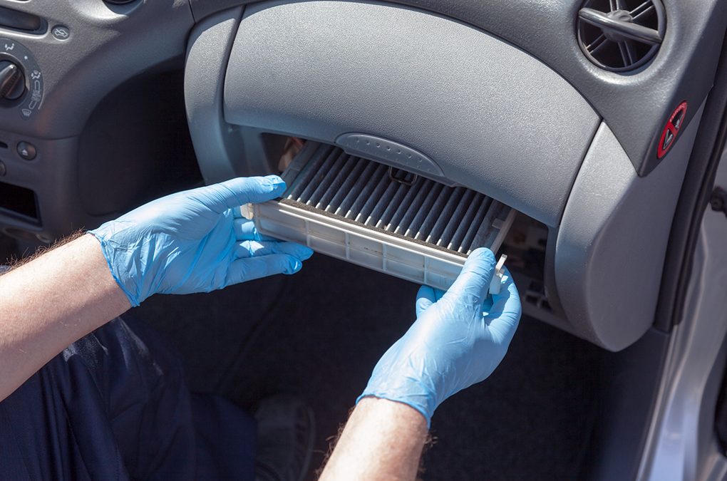 person removing air conditioner unit from car